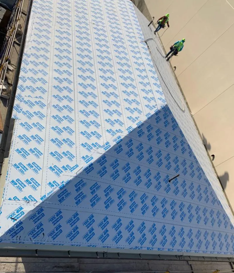 Professional roofers installing underlayment on a metal roof in Pantops